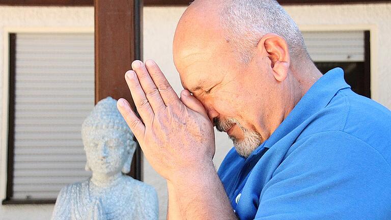 Ehrfurcht vor dem Buddha: Khalil Abdel Rahman vor der Statue im Biergarten des Sennfelder Naturfreundehauses.