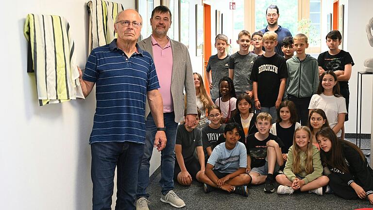 Wolfgang Weismantel (links) und Bernd Rottenbacher (neben Wolfgang Weismantel) haben am vergangenen Donnerstag vor der Klasse 5b mit deren Kunstlehrer Hans Wirsching (hinten) zwei Bilder von ehemaligen Kunstlehrern des Gymnasiums enthüllt.