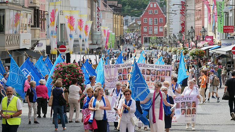 Die Prozession angeleitet von der Fahnenträgerin und dem geschäftsführenden Vorstand nähert sich dem Dom, wo sie von dem Bischof Franz Jung in Empfang genommen wird.