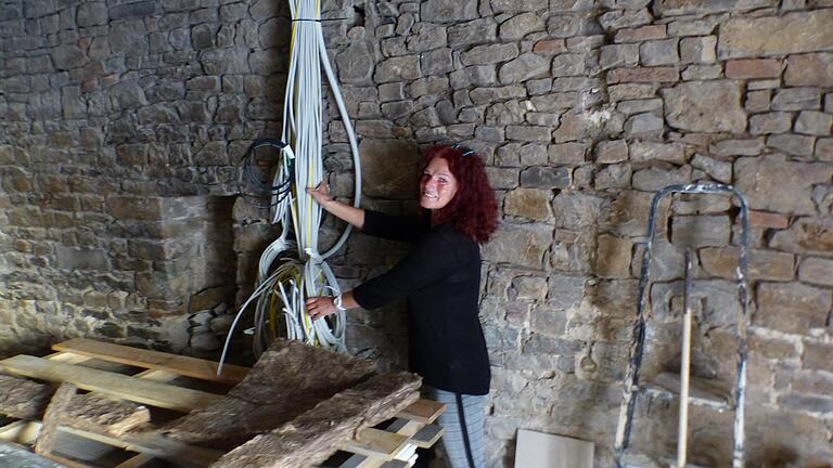 Andrea Haupt ordnet an der seitlichen Bruchsteinmauer einen Kabelstrang. Die Mauer soll als Blickfang so erhalten bleiben. Andrea Haupt ordnet an der seitlichen Bruchsteinmauer einen Kabelstrang. Die Mauer soll als Blickfang so erhalten bleiben.