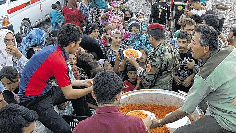 Flüchtlingsnot: Soldaten im nordirakischen Erbil verteilen Essen an Syrer, die wegen der anhaltenden Kämpfe aus ihrem Heimatland geflohen sind. Flüchtlingsnot: Soldaten im nordirakischen Erbil verteilen Essen an Syrer, die wegen der anhaltenden Kämpfe aus ihrem Heimatland geflohen sind.