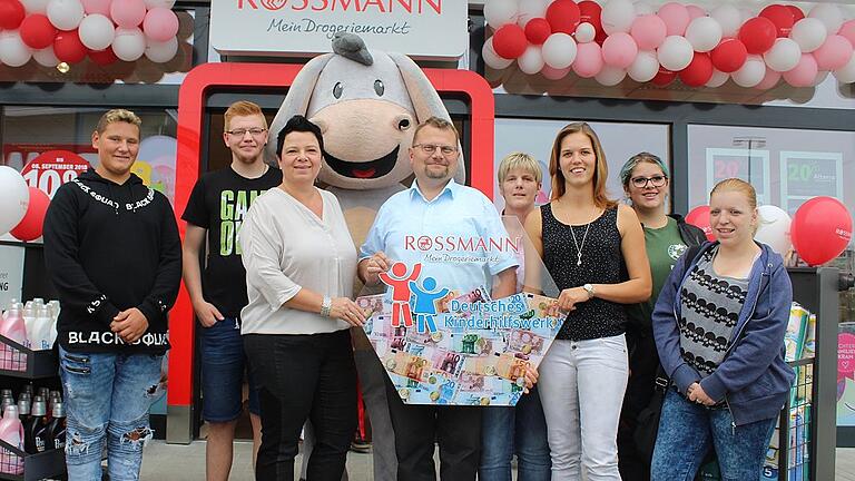 1000 Euro für Jugendarbeit - Am 1. September eröffnete die Filiale der Drogeriekette Rossmann eine Filiale in Wiesentheid. Im Gewerbegebiet an der Korbacher Straße bietet der Markt nun auf einer Verkaufsfläche von 760 Quadratmetern seine Produkte an, zwölf Angestellte sind dort tätig. Wiesentheids Bürgermeister Werner Knaier freute sich, dass die Gemeinde nun um den ersehnten Drogeriemarkt reicher ist. Zusammen mit Jugendhausleiterin Ivonne Berthel (rechts vorne) und einigen Jugendlichen nahm Knaier einen Scheck über 1000 Euro in Empfang, den das Unternehmen für die Jugendarbeit in der Gemeinde spendierte. Für die ersten 1000 Kunden spendete das Unternehmen je einen Euro, das Geld geht an die offene Jugendarbeit in Wiesentheid. Wie Deborah Lawson-Schmidt (links vorne) von der Rossmann-Bezirksleitung Unterfranken sagte, werden künftig Spendendosen an den Kassen der Filiale stehen. Deren Einnahmen kommen dem Deutsche Kinderhilfswerk zugute. 1000 Euro für Jugendarbeit - Am 1. September eröffnete die Filiale der Drogeriekette Rossmann eine Filiale in Wiesentheid. Im Gewerbegebiet an der Korbacher Straße bietet der Markt nun auf einer Verkaufsfläche von 760 Quadratmetern seine Produkte an, zwölf Angestellte sind dort tätig. Wiesentheids Bürgermeister Werner Knaier freute sich, dass die Gemeinde nun um den ersehnten Drogeriemarkt reicher ist. Zusammen mit Jugendhausleiterin Ivonne Berthel (rechts vorne) und einigen Jugendlichen nahm Knaier einen Scheck über 1000 Euro in Empfang, den das Unternehmen für die Jugendarbeit in der Gemeinde spendierte. Für die ersten 1000 Kunden spendete das Unternehmen je einen Euro, das Geld geht an die offene Jugendarbeit in Wiesentheid. Wie Deborah Lawson-Schmidt (links vorne) von der Rossmann-Bezirksleitung Unterfranken sagte, werden künftig Spendendosen an den Kassen der Filiale stehen. Deren Einnahmen kommen dem Deutsche Kinderhilfswerk zugute.