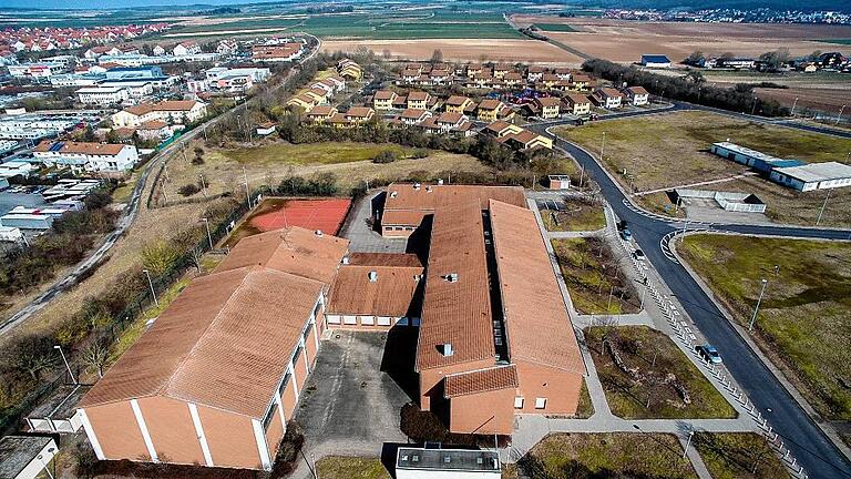 Die Holzhäuser im Hintergrund werden verkauft. In die ehemalige High School zieht die International School Mainfranken ein.