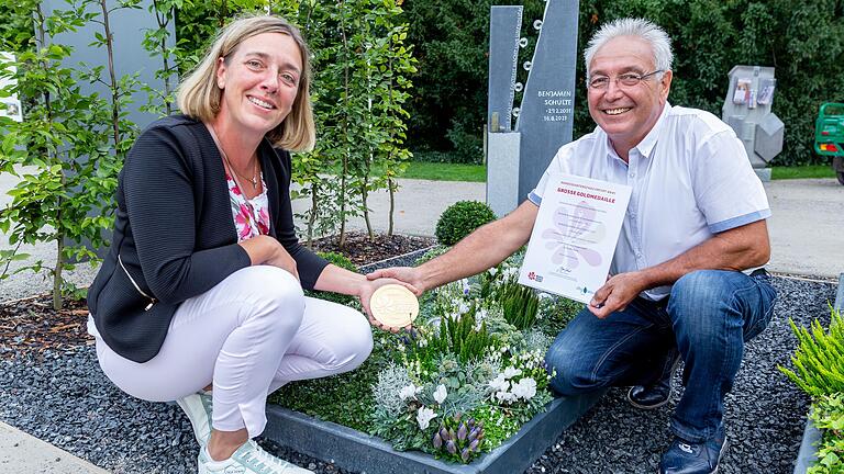 Petra und Hans Joachim Steger, Inhaber der Friedhofsgärtnerei Steger aus Würzburg, haben bei der Bundesgartenschau in Erfurt 2021 eine große Goldmedaille gewonnen. Prämiert wurde die Herbstgestaltung ihres Einzelgrabs für einen fiktiven zehnjährigen Jungen.