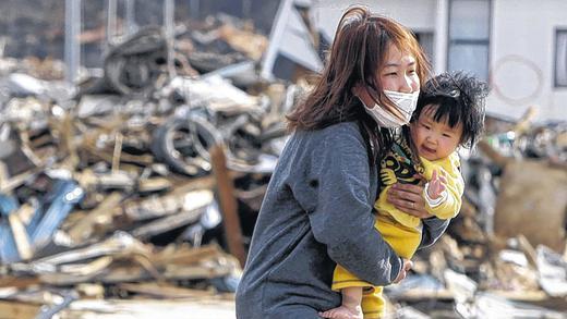 Macht der Natur und Ohnmacht der Menschen: Eine Mutter trägt ihr Kind durch die verwüstete Stadt Yamada. Oben: die Tsunamiwelle rollt auf die Stadt Miyako zu. Macht der Natur und Ohnmacht der Menschen: Eine Mutter trägt ihr Kind durch die verwüstete Stadt Yamada. Oben: die Tsunamiwelle rollt auf die Stadt Miyako zu.