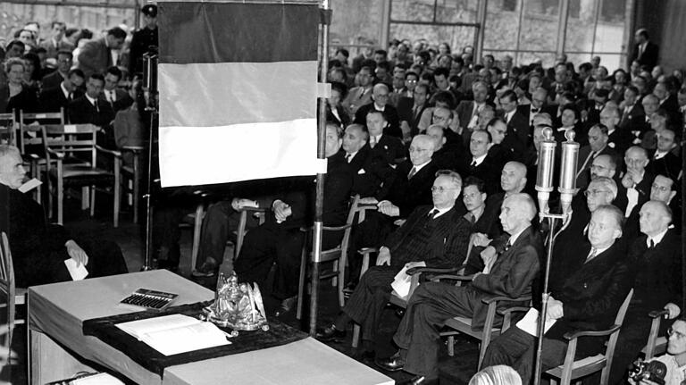 Unter einer schwarz-rot-goldenen Standarte liegt am 23.Mai 1949 das Grundgesetz der Bundesrepublik Deutschland auf einem Tisch im Sitzungssaal des Parlamentarischen Rates in Bonn.