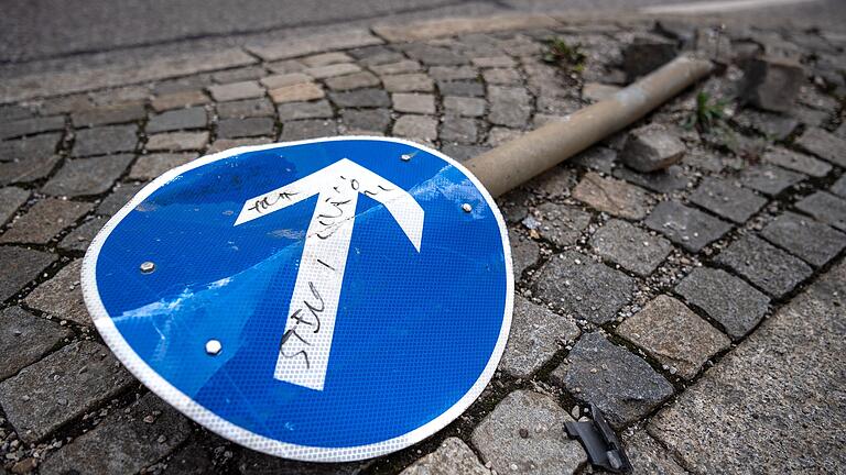 Ein beschädigtes Verkehrsschild liegt auf einer Verkehrsinsel. Schäden an Verkehrsschildern kosten Bayerns Städte viel Zeit und Geld. Auch die Gefahr von Unfällen steigt. Ein beschädigtes Verkehrsschild liegt auf einer Verkehrsinsel. Schäden an Verkehrsschildern kosten Bayerns Städte viel Zeit und Geld. Auch die Gefahr von Unfällen steigt.