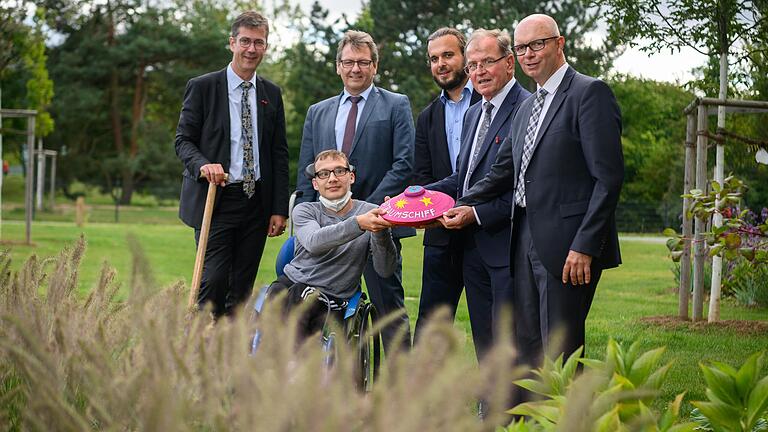 Neueröffnung des Jakob-Riedinger-Hauses: (v. l.) Oberbürgermeister Christian Schuchardt, Bewohner Dominik Valent, Jürgen Oswald, Geschäftsleiter Krankenhäuser und Heime, Heimleiter Sven Vinzens, Bezirkstagspräsident Erwin Dotzel und Verwaltungsleiter Heiko Lörner vergraben&nbsp; eine Zeitkapsel.