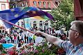 Der Volkacher Sebastian Kleinau schwenkte kurz vor Beginn der Stadtratssitzung die Europaflagge mit Regenbogen vom Rathausbalkon, um seine Solidarität mit Geflüchteten zu zeigen. Unten auf dem Marktplatz hatten sich Gegner des geplanten Flüchtlingsheims versammelt.