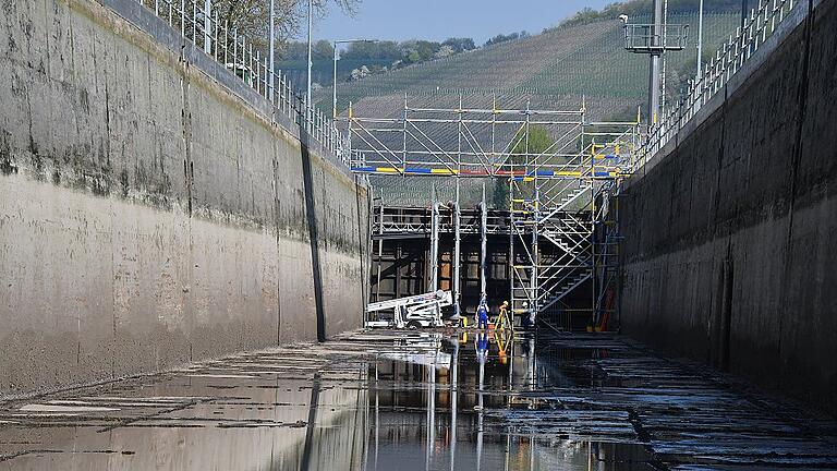 Winzig wirken die Mitarbeiter des Wasser- und Schifffahrtsamts in der riesigen Kammer der Schleuse Randersacker.