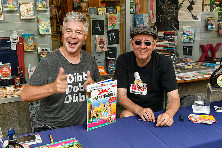 Gunther Schunk und Kai Fraass signierten vor der Buchhandlung Schöningh ihren&nbsp;Jubiläumsband 'Asterix un di Marktbärbel', der am 5. Juni erscheinen ist.