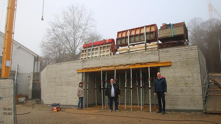 Mit dem Bau einer Stützmauer gelang eine flächenmäßige Erweiterung des darüber angeordneten Kindergartengeländes. In die Mauer integriert ist talseits eine Buswartehalle, von deren Fertigstellung sich  Bürgermeisterin Karin Kuhn (Bürgermitte Greußenheim), Bauunternehmer Harald Schebler und Architekt Andreas Hanisch (im Bild von links) überzeugten.