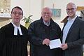 Pfarrer Stefan Stauch (links) und der Dirigent des Posaunenchores, Christian Heinemann (rechts), übergeben an den Vorsitzenden der Indio-Hilfe-Peru, Emil Heinemann (Mitte), eine Spende von 1262 Euro. Der Erlös stammt aus einem Konzert des Posaunenchores zum Reformationsfest.