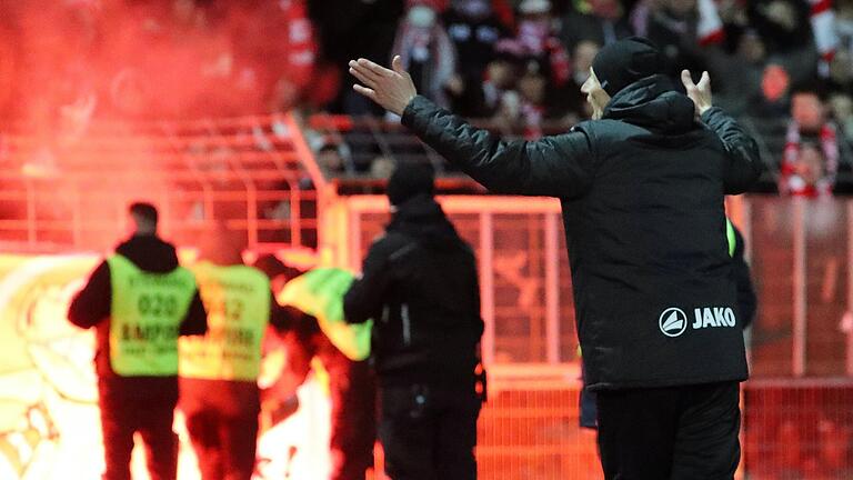 Unsinn im Überschwang: Die Kickers-Fans feiern die Tore ihrer Mannschaft nach der Pause mit Bengalos, Trainer Ralf Santelli versucht zu beschwichtigen.