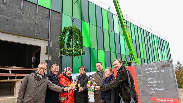 Die grüne Fassade der neuen Produktionhalle in Ochsenfurt-Hohestadt steht sinnbildlich für die Nähe der Kneipp GmbH zur Natur. Beim Richtfest (von links): Jürgen Bode (IHK), Bürgermeister Peter Juks, Stefanie Riedel (Riedel Baa), Roland Hauck und Alexander C. Schmidt (Kneipp) sowie die Architekten Pia Schriever und Jürgen Rustler.