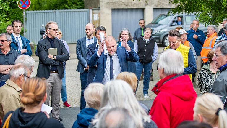 Landrat Thomas Eberth (Mitte) diskutiert mit Bürgerinnen und Bürgern auf dem Parkplatz in Fährbrück über die Inhalte eines anonymen Flugblattes zur Zukunft des Augustinerklosters.