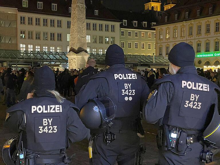 Polizeikräfte im Einsatz bei einer 'Querdenker'-Demonstration am Unteren Markt in Würzburg im Jahr 2021.