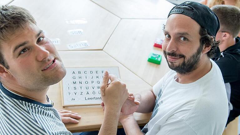 Training der fünf Sinne: Heute ist in der Tagesförderstelle in Schweinfurt Schmecken an der Reihe. Die Betreuer Marc Kaut und Julia Küllstädt mit Tobias (links) und Robin (rechts) sind stolz auf ihre Schützlinge.