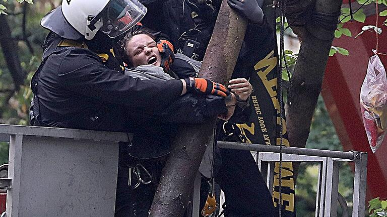 Hambacher Forst       -  Polizisten ziehen einen Umweltaktivisten von einem Baumgerüst. Mit einem massiven Aufgebot haben die Behörden im Braunkohlerevier Hambacher Forst die Räumung begonnen.