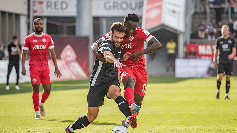 Benjika Caciel (19) von den Würzburger Kickers im Ballduell mit Luis Sailer Fidalgo (19) vom FC Memmingen. Die Würzburger Kickers spielen am Freitag Abend 21.07.23 gegen den FC Memmingen 0:0 in der AKON Arena in Würzburg.