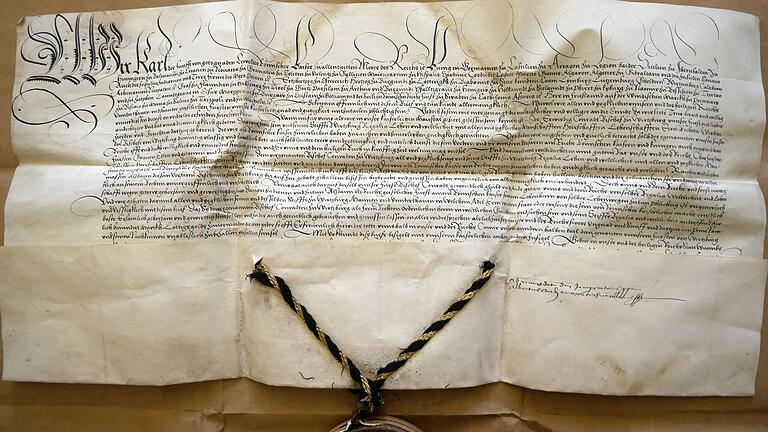 Kaiser Karl V. bestätigt, datiert auf den 4. März 1521, Bischof Konrad von Thüngen die Regalien und Lehen des Hochstifts Würzburg. Ausgefertigt wurde die Urkunde durch den Erzkanzler Albrecht von Brandenburg, Erzbischof von Mainz. Rechts unten dessen handschriftlicher Vermerk 'ad mandatum domini imperatoris proprium' ('Auf unmittelbaren Befehl des Kaisers').