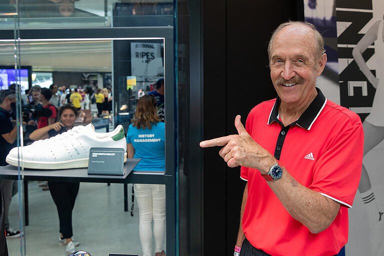 Der frühere Tennis-Star Stan Smith steht beim Sportartikelhersteller Adidas neben seinem gleichnamigen Schuh.