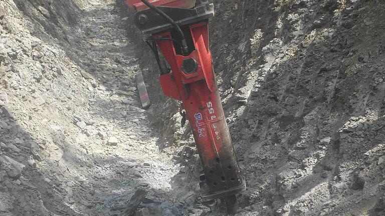 Bauarbeiten an der Staatsstraße 2292, Abzweigung nach Ostheim: Im Bereich der Drainage-Leitungen war der Untergrund so hart, dass sich ein spezieller Meißelbagger zentimeterweise vorarbeiten musste. Bauarbeiten an der Staatsstraße 2292, Abzweigung nach Ostheim: Im Bereich der Drainage-Leitungen war der Untergrund so hart, dass sich ein spezieller Meißelbagger zentimeterweise vorarbeiten musste.
