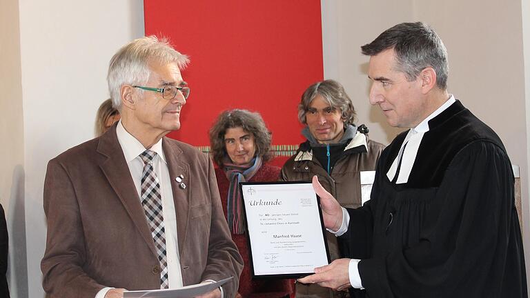 Manfred Haase erhält von Pfarrer Matthias Hörning die Urkunde.&nbsp;