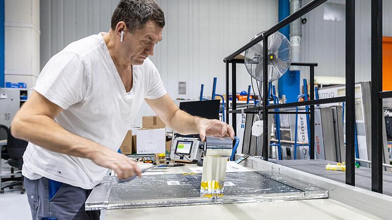 Mitarbeiter Jost Alex beim Zusammenkleben und Befestigen der Isolierplatten (VIPs). Mitarbeiter Jost Alex beim Zusammenkleben und Befestigen der Isolierplatten (VIPs).