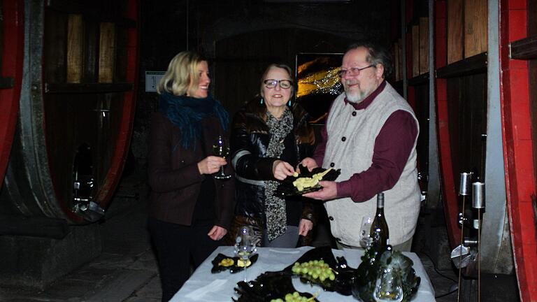 An der mit Weinflaschenkunst dekorierten Tafel erklärt Petra Markert (links) im Hammelburger Holzfasskeller den Kunstvereint-Mitgliedern Maria Rinecker und Rainer Stein Details ihres Schaffens. Winfried Ehling       -  An der mit Weinflaschenkunst dekorierten Tafel erklärt Petra Markert (links) im Hammelburger Holzfasskeller den Kunstvereint-Mitgliedern Maria Rinecker und Rainer Stein Details ihres Schaffens. Winfried Ehling