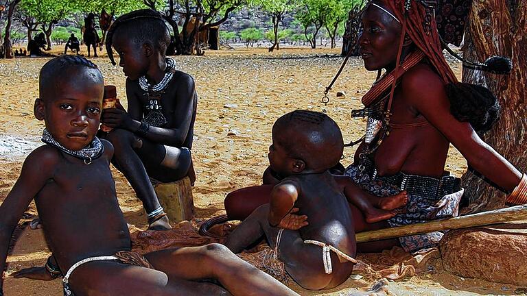 Besuch bei den Himbas: Eines der letzten Nomadenvölker, hier eine Himbafrau mit Kindern in Originaltracht.