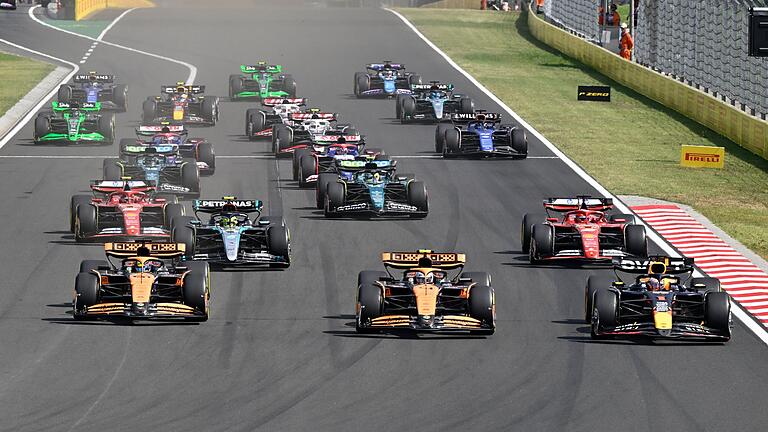 Großer Preis von Ungarn       -  Max Verstappen (r.), Lando Norris (m.) und Oscar Piastri biegen praktisch gleichauf in die erste Kurve ein.