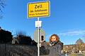 Ute Pawlik sucht mit ihrem Handy am Ortseingang von Zell im Landkreis Schweinfurt nach Empfang. Im ganzen Ort haben Kunden der Telekom keinen oder nur schlechten Empfang.