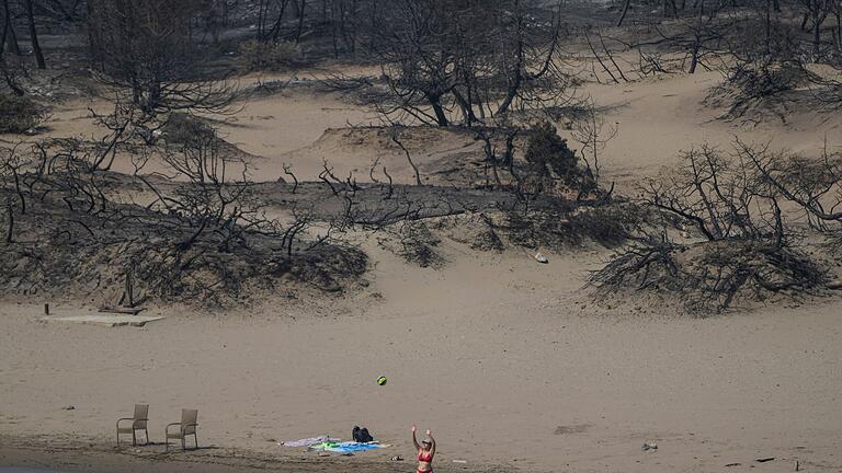 Waldbrände auf Rhodos.jpeg - Hinten die verbrannte Vegetation, vorn das Mittelmeer. Ein Strand bei Gennadi auf Rhodos. Waldbrände auf Rhodos.jpeg - Hinten die verbrannte Vegetation, vorn das Mittelmeer. Ein Strand bei Gennadi auf Rhodos.