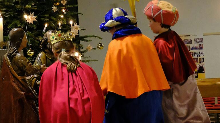 Sternsinger vor der Krippe.