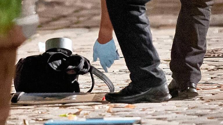Bombenanschlag in Ansbach - Ein Polizist bückt sich nach dem Rucksack des Syrers. Bombenanschlag in Ansbach - Ein Polizist bückt sich nach dem Rucksack des Syrers.