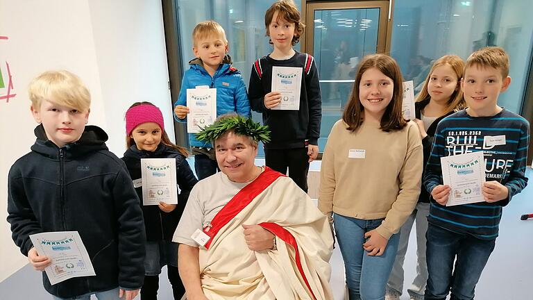 Die Kinder erwarben zunächst ihr erstes Latein-Zertifikat mit „summa cum laude“, also „mit höchstem Lob', bevor sie sich mit dem in Toga gekleideten „Senator“ Justus Finkel dem Fotografen präsentierten.&nbsp;