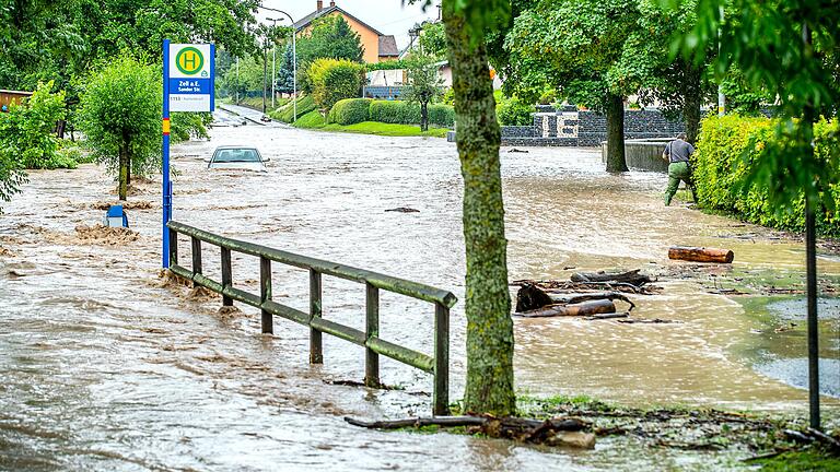 Die Sander Straße im Knetzgauer Ortsteil Zell ist überflutet, ein Auto ist fast komplett unter Wasser: Der Haßbergkreis war vom Starkregen im Juli besonders betroffen.&nbsp;