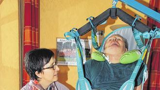 Fast eine Viertelstunde benötigt Monika Betz trotz Lift und Routine, um ihren Mann aus dem Rollstuhl ins Bett zu bringen. Nach zwei bis drei Stunden wird für den Wachkoma-Patienten das Sitzen zu anstrengend. Nicht nur zu liegen, ist aber vor allem wichtig für die Lungenfunktion.