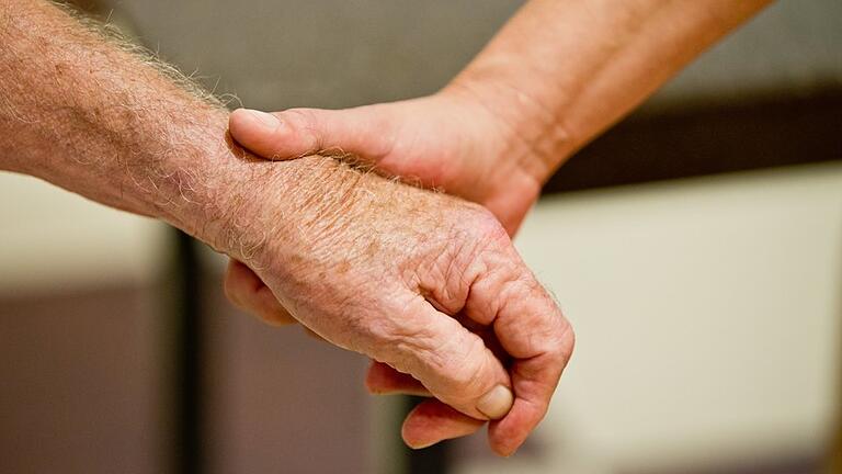 Demenz       -  Eine auf Demenzkranke spezialisierte Altenpflegerin hält die Hand eines demenzkranken Mannes.