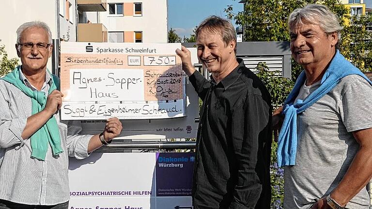 Eigenheimer-Vorsitzender Reinhold Günther übergibt die Spende von 750 Euro an Udo Hafner vom Agnes-Sapper-Haus gemeinsam mit Musiker Siggi Juhasz.