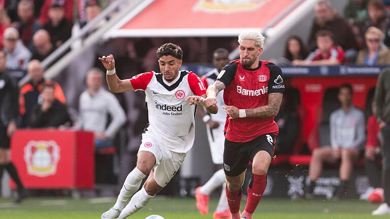 Bayer Leverkusen - Eintracht Frankfurt       -  Torschützen unter sich: Leverkusens Robert Andrich (r) und Frankfurts Omar Marmoush im Duell um den Ball.