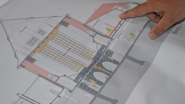 Architekt Matthias Knab zeigt auf die Pläne zur Sanierung der alten Ochsenkathedrale.