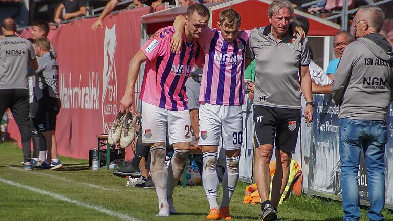 Philipp Harlaß (Mitte) verletzte sich im Heimspiel des TSV Aubstadt gegen den SV Schalding-Heining kurz nach seiner Einwechslung und musste von Marco Nickel (links) und Mannschaftsarzt Dr. Peter Trus vom Feld geführt werden.