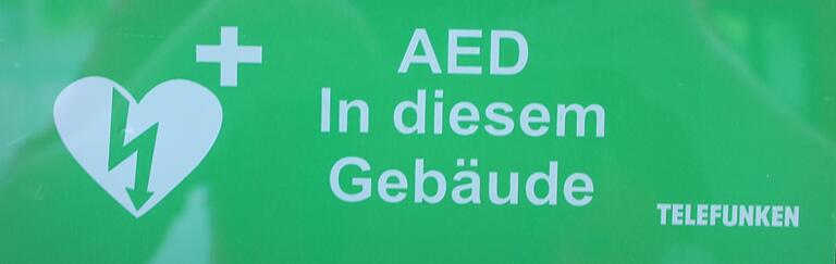 Die grünen Schilder zeigen an, dass sich ein öffentlich zugänglicher Defibrillator im Gebäude befindet.