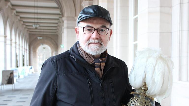 Ludwig Büchner in zivil. in den Arkaden In der Hand hält er den Helm, den er für seine Darstellung als König Ludwig III. braucht. Foto: Benedikt Borst       -  Ludwig Büchner in zivil. in den Arkaden In der Hand hält er den Helm, den er für seine Darstellung als König Ludwig III. braucht. Foto: Benedikt Borst