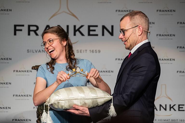 Eva Brockmann gibt die Krone der Fränkischen Weinkönigin zurück. Rechts im Bild: Moderator Axel Robert Müller.