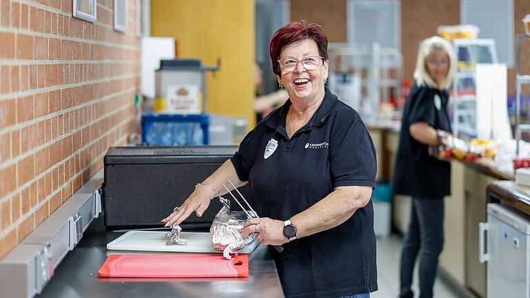 Monika Courte bereitet den warmen Leberkäse für die Speisetheke bei den Heimspielen der Würzburg Baskets vor.