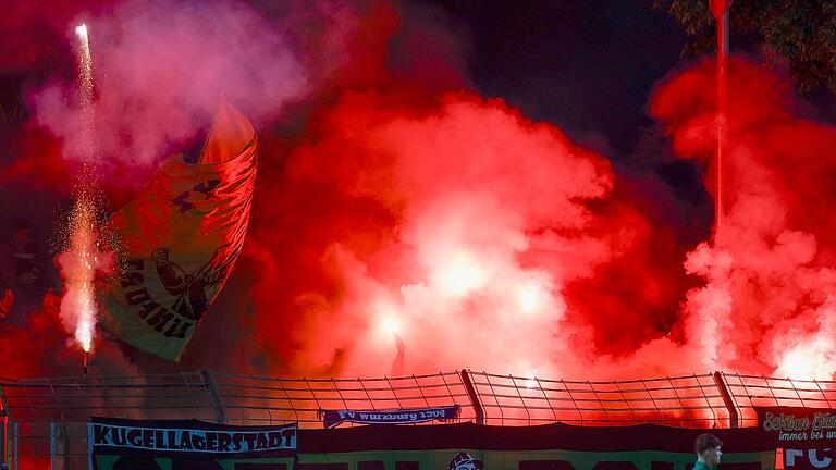 Pyro-Wahnsinn in Schweinfurt: Während im 05-Block Bengalos glühen, schießen einzelne 'Fans' Feuerwerksraketen ab – links und rechts am Bildrand zu sehen.