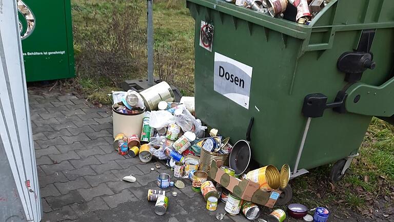 Am Niederwerrner Ostring stapelt sich der Müll im und neben dem Container.